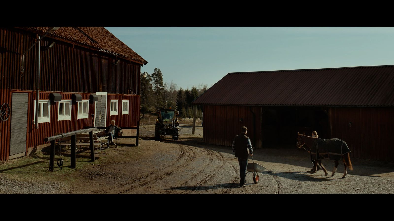 a man leading a horse out of a barn