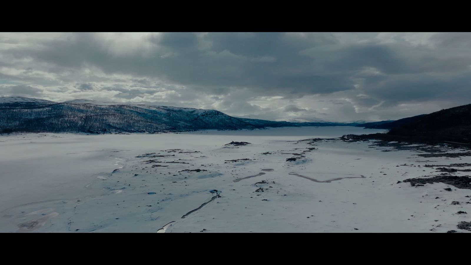 a snow covered landscape with mountains in the distance