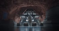 a woman riding an escalator in a tunnel