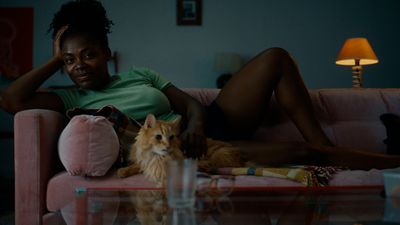 a woman sitting on a couch next to a cat