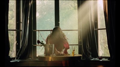 a woman sitting at a table in front of a window