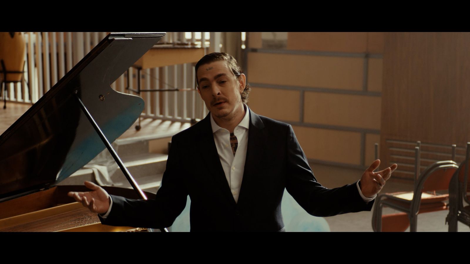 a man standing next to a piano in a room