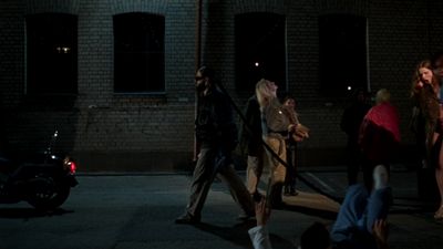 a group of people walking down a street at night