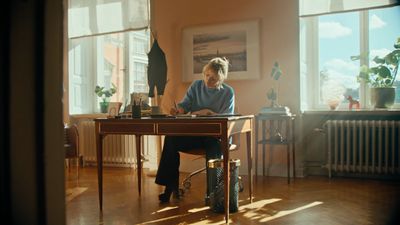 a man sitting at a desk in front of a window