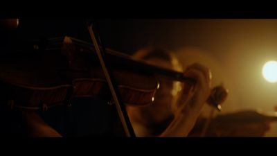 a person playing a violin in a dark room