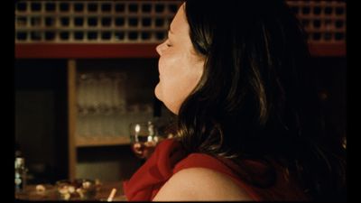 a woman in a red dress sitting at a bar