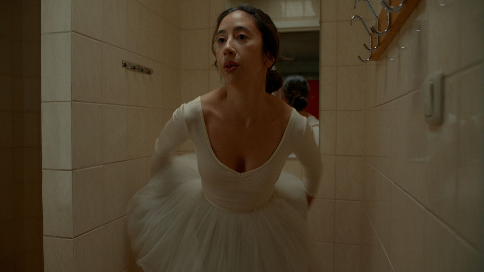 a woman in a white dress standing in a bathroom