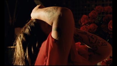 a woman in a red dress with tattoos on her back