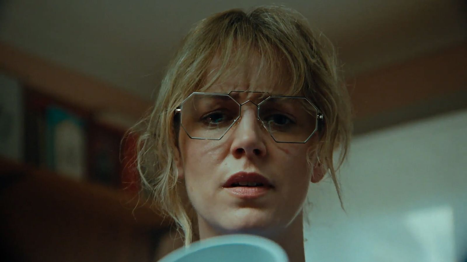 a woman with glasses holding a blue frisbee