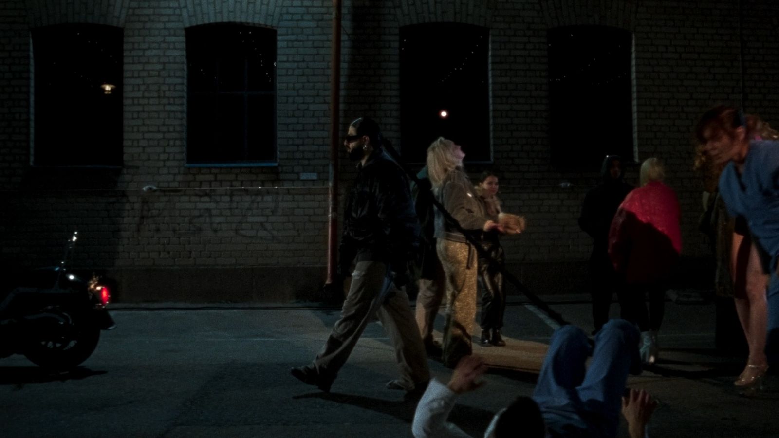 a group of people walking down a street at night