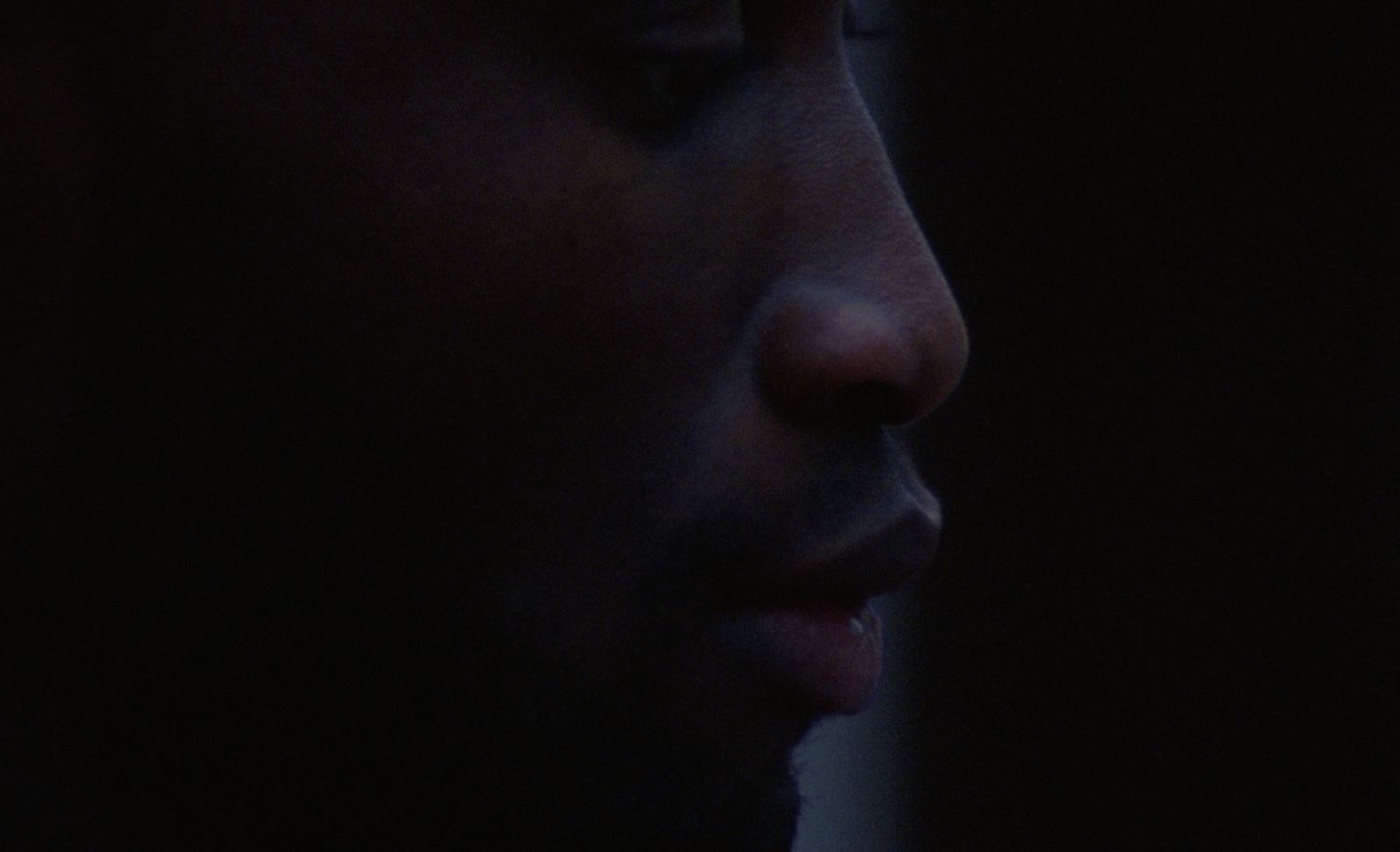 a close up of a man's face in the dark