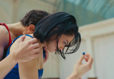 a woman in a blue tank top holding a cell phone