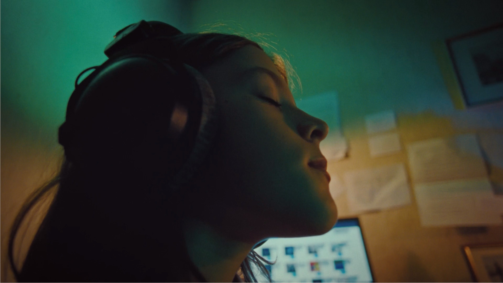 a girl wearing headphones in a dark room