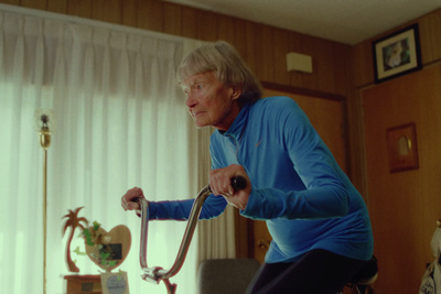 an older woman is using a walker in a living room