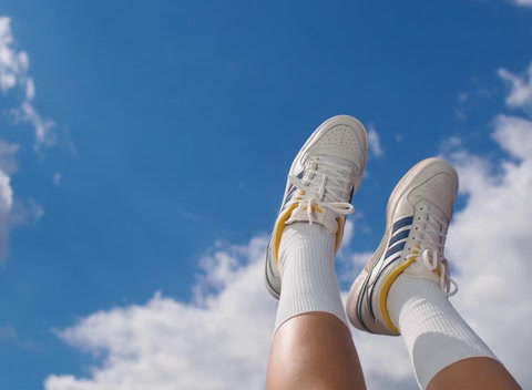 a person's legs with white socks and tennis shoes