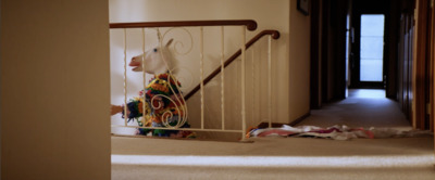 a stuffed animal on a stair railing in a house