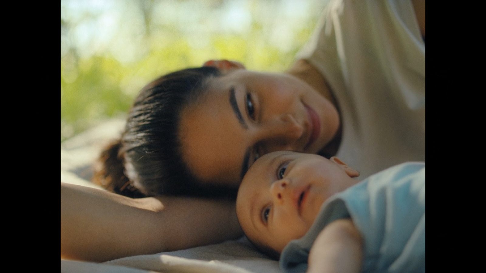 a woman and a child laying on a bed