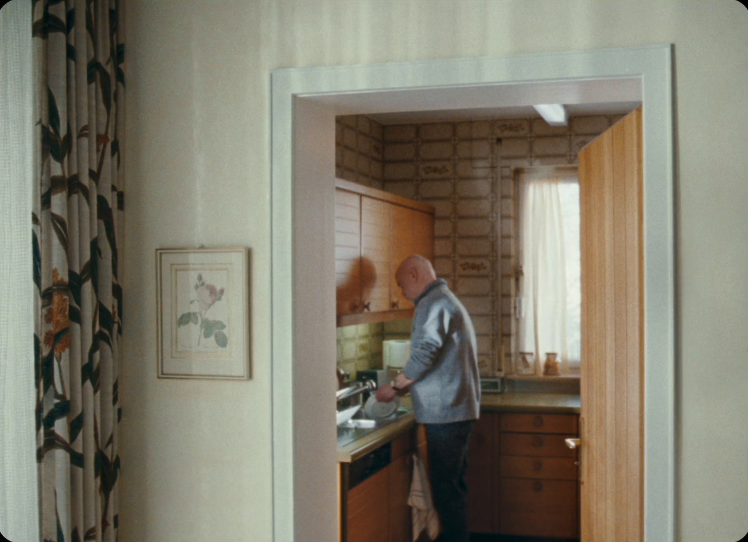 a man standing in a kitchen next to a sink