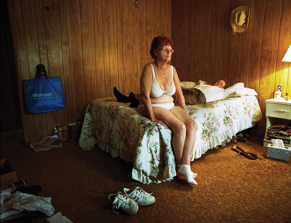 a woman sitting on a bed in a bedroom