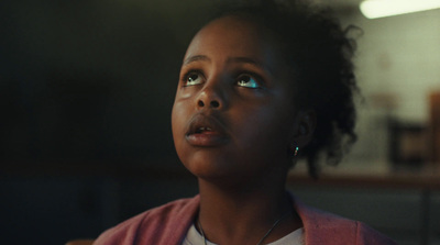 a young girl with blue eyes stares upward