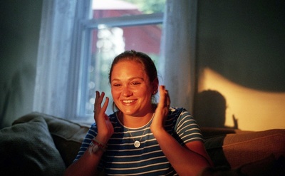 a woman sitting on a couch with her hands in the air