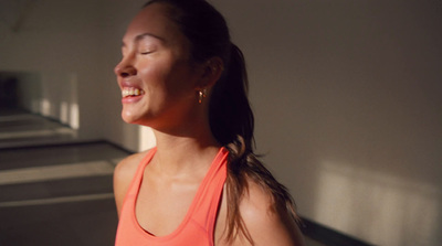 a woman in an orange tank top laughing