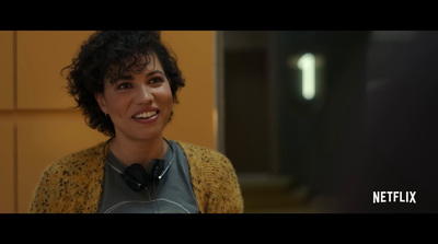 a woman with curly hair smiling at the camera