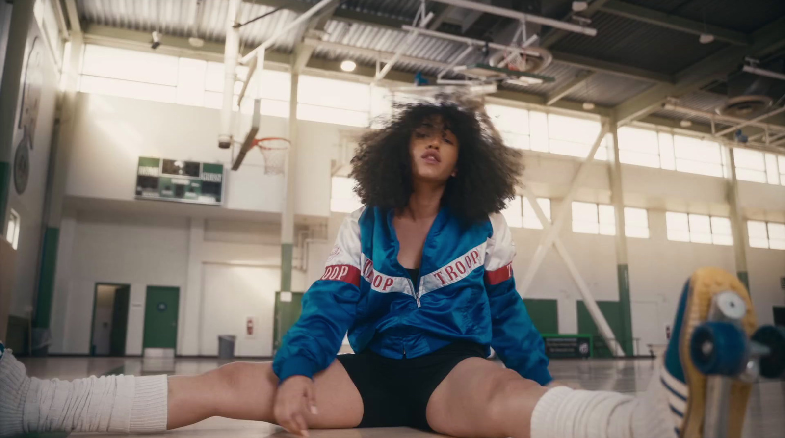 a woman sitting on the floor in a gym