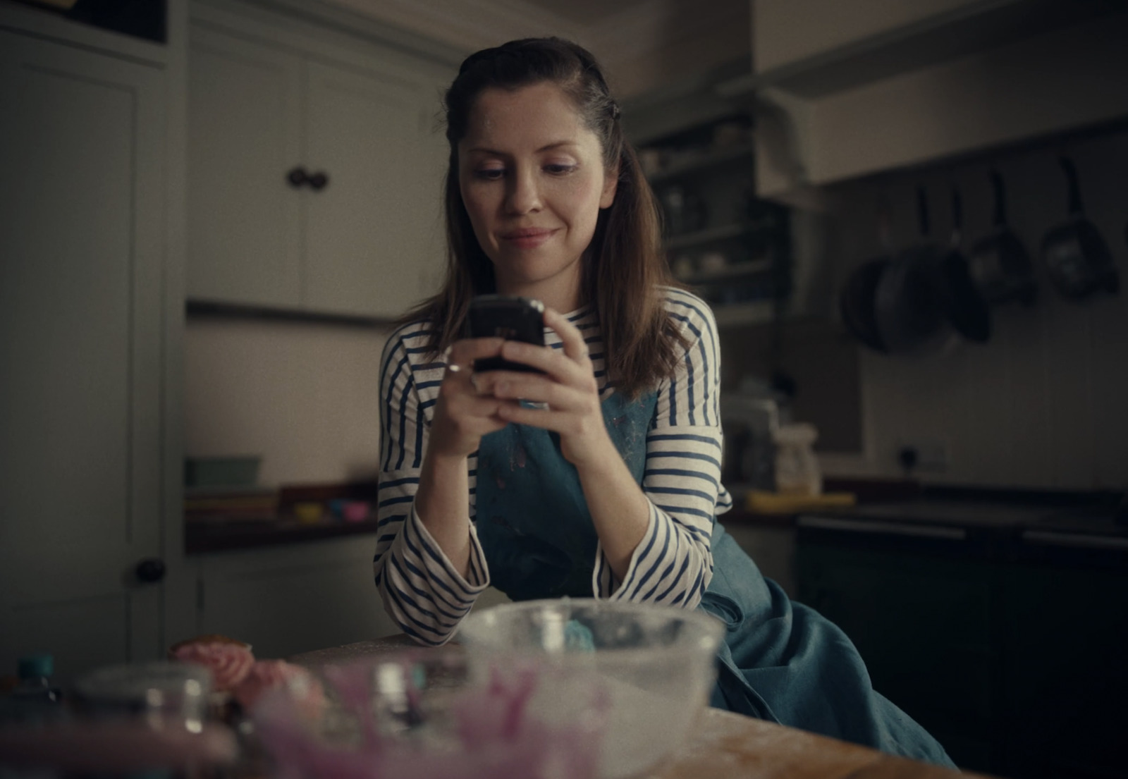 a woman sitting at a table looking at her cell phone