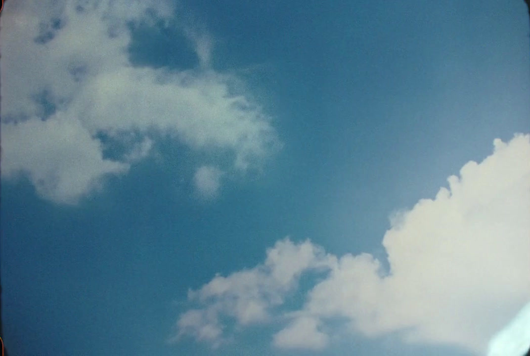 a plane flying through a blue cloudy sky