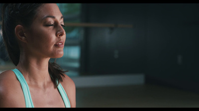 a woman in a blue tank top looking down