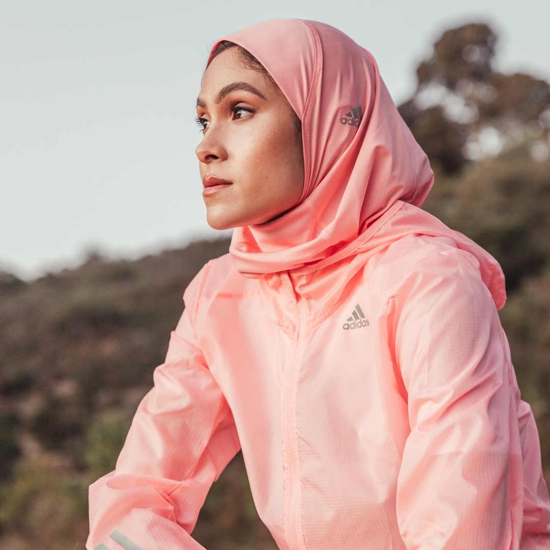 a woman wearing a pink jacket and head scarf