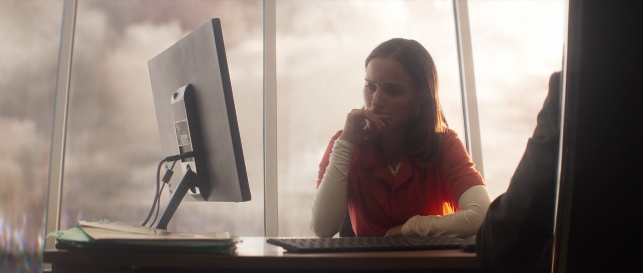 a woman sitting at a desk in front of a computer