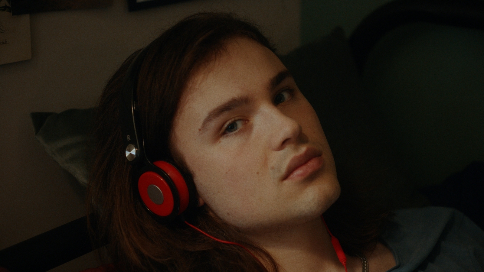 a young man wearing red headphones in a dark room