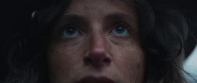 a close up of a woman's face with blue eyes