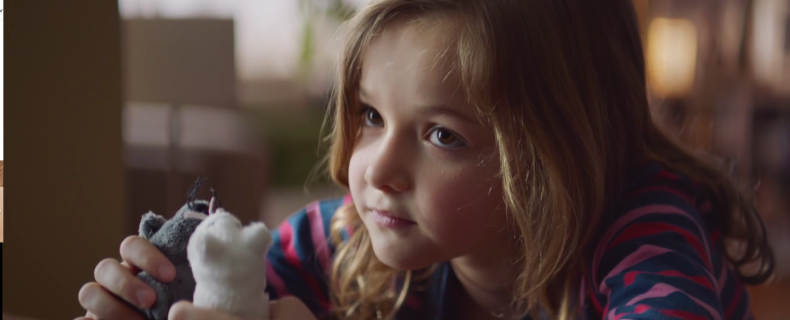 a young girl is holding a stuffed animal