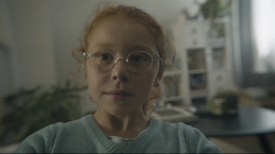 a young girl wearing glasses in a living room