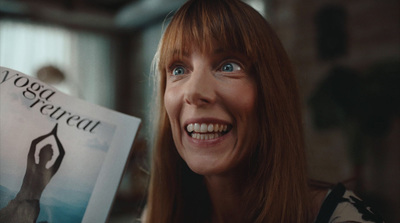 a woman smiling and holding a yoga magazine