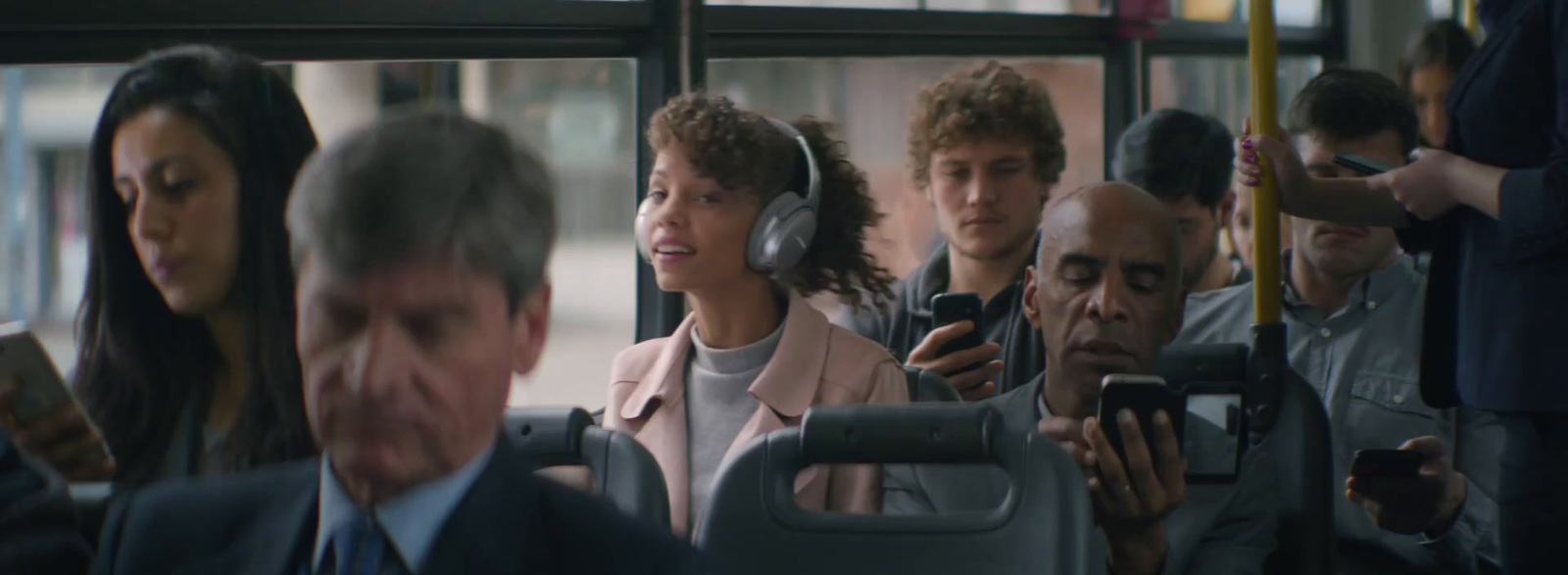 a group of people on a bus talking on their cell phones