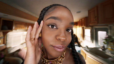 a woman in a kitchen holding her hand up to her face