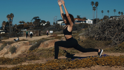 a woman doing a yoga pose on a beach