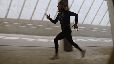 a woman in a black top and leggings running