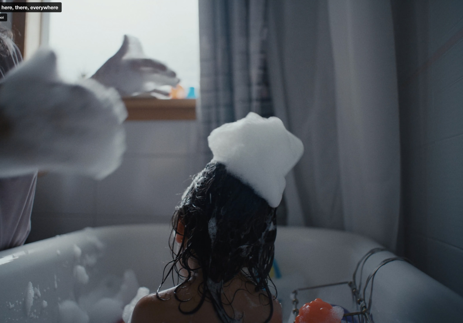 a little girl is taking a bath in a bathtub