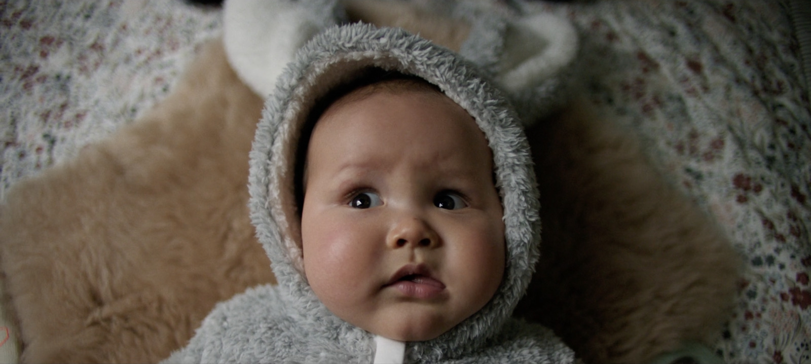 a baby in a bunny costume laying on a bed