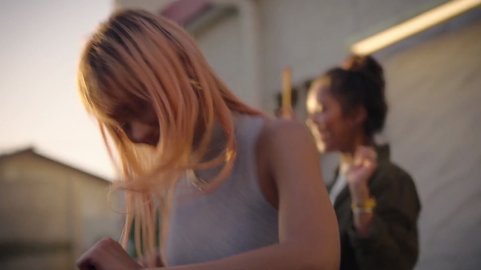 a woman standing next to another woman holding a cell phone