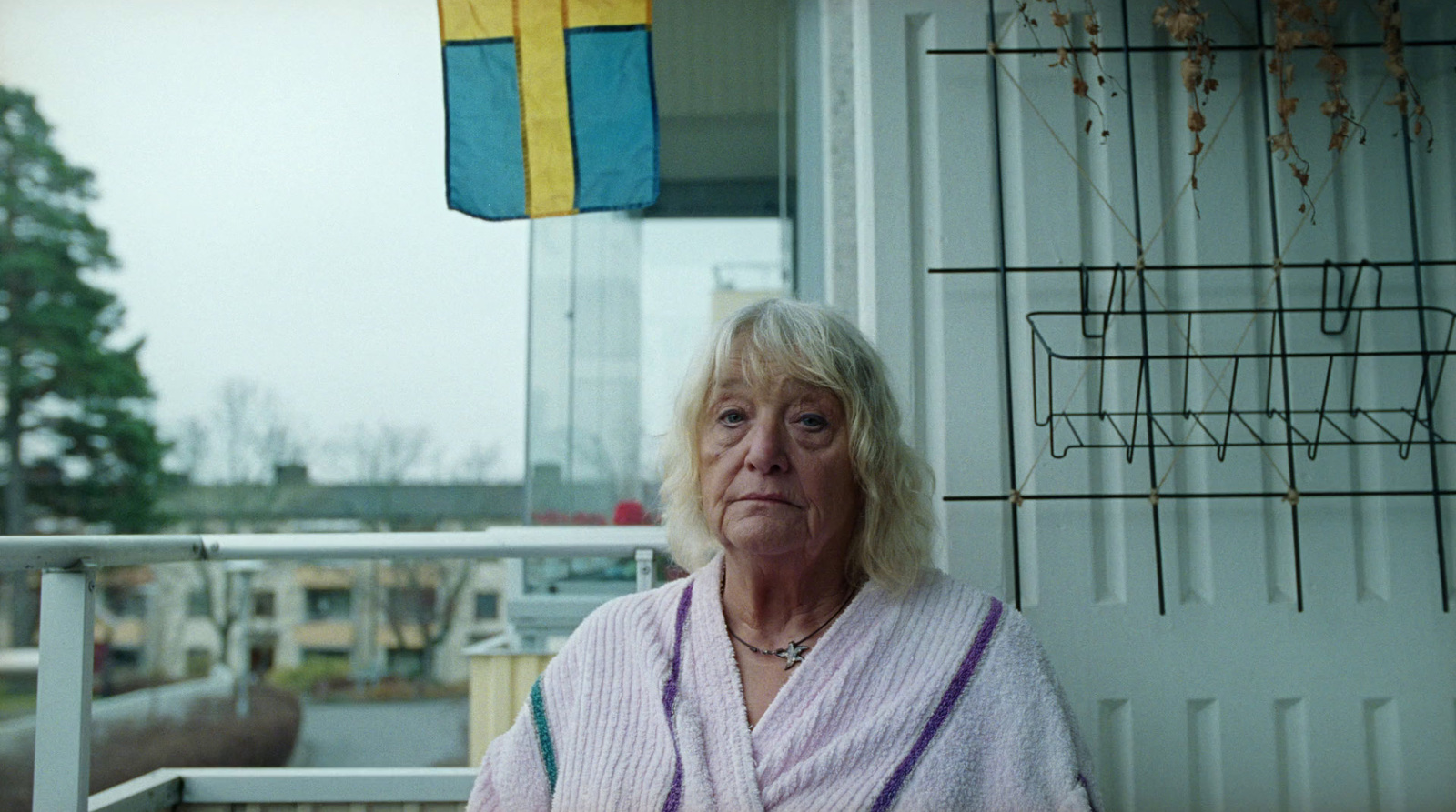  an older woman standing outside of a house