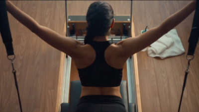 a woman in a black top is on a treadmill