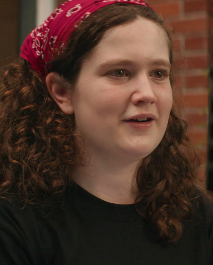 a woman with curly hair wearing a bandana