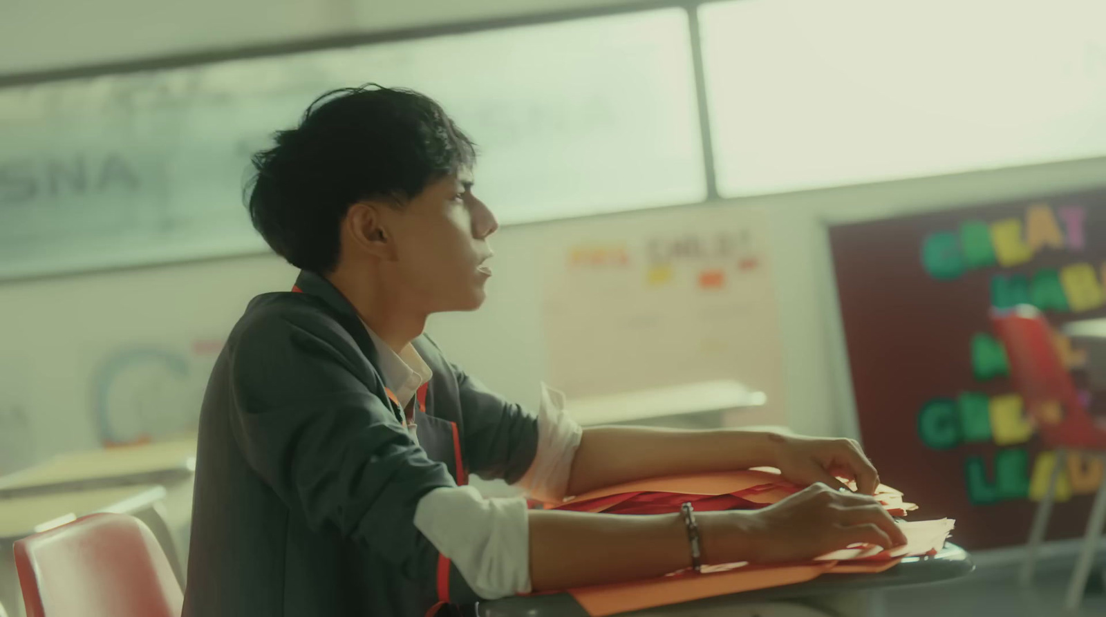 a woman sitting at a desk in a classroom