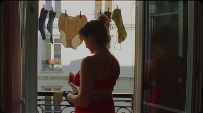 a woman in a red bikini looking out a window